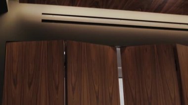 Modern bir asansör şık, zarif bir iç mekan sergiliyor. Şık ahşap kaplama ve rafine ışıklandırma tasarımı ile tamamlanmış.