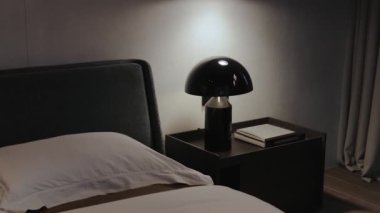 Minimalist tasarım elementleriyle birlikte parlak bir lamba içeren modern ve çağdaş bir yatak odası sahnesi.