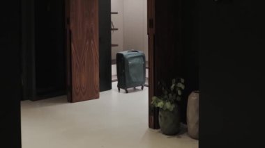 Modern bir iç mekanda gardıropta duran bir bavul, çağdaş modern tasarımın etkin bir şekilde sergilendiği minimalist bir ortam.
