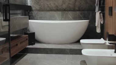 Zarif ve çağdaş bir banyo. Minimalist tasarım elementleriyle eşleştirilmiş şık bir küvet sergiliyor.