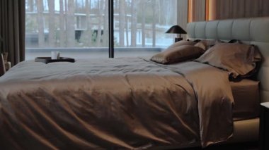 Bu modern yatak odasının tüm parlaklığını ve rahatlığını arttıran şık bir yatağı ve geniş pencereleri var.