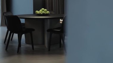 Yeşil elmalı yuvarlak bir masası olan bir yemek alanı modern iç tasarım estetiği için mükemmel.