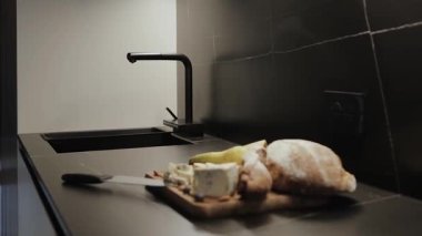 Ekmek, peynir ve zarif modern dekor aksanlarına sahip şık bir mutfak.