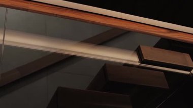 Modern mimari zarafet ve yeniliğin güzelliğini vurgulayan şık bir cam ve ahşap merdiven.