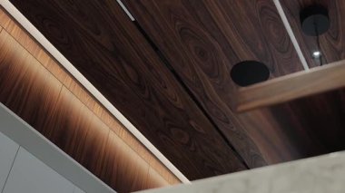 Zarif ve zarif bir iç mekan. Gösterişli, modern aydınlatma elementleriyle tamamlanmış zengin ahşap dokular sergiliyor.