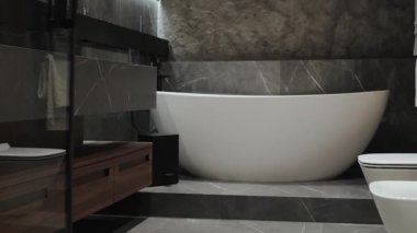 Burası şık ve modern bir banyo. Lüks kaplıcaların yanında güzel ve serbest bir küvet sergiliyor.