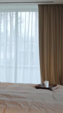 Yumuşak tonlara, katıksız perdelere ve samimi ve davetkar bir ortam yaratan şık ve modern bir yatak odası. Dikey video