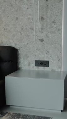 Gösterişli gri bir yan masa büyüleyici bir duvar tasarımı ile süslenmiş şık bir oturma odasını mükemmel bir şekilde tamamlıyor. Dikey video