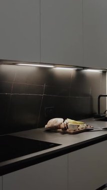 Üzerinde peynir, ekmek ve üzümlerin pohpohlandığı mermer bir yüzeyi olan siyah bir mutfak. Büyüleyici bir etki yaratmak için şık ışıklandırma