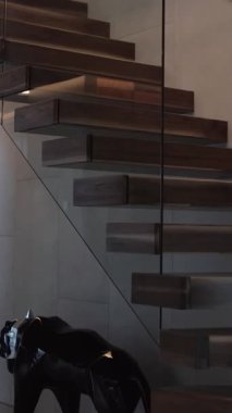 Dikey video. Cam ve güzel ışıklandırmalı ahşap merdivenlerin modern tasarımı. 4k video
