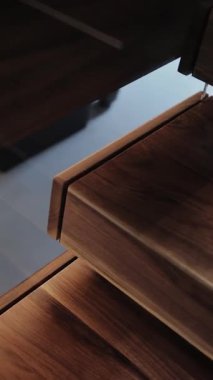 Ahşap merdivenlere yakın çekim. Kamera sorunsuz çalışıyor. Lüks Modern Daire İçi. Dikey video. 4k