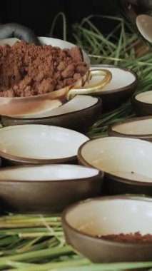Şefin ellerinin tabağa yemek koyduğu yakın çekim. Çikolatanın kırsal kaselerle sunumu ve mükemmel bir eşlik eden dikey video.