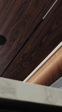 Modern bir iç mekan, lüks bir daire ya da mutfakta ışıklandırılmış ahşap bir tavana yakın çekim. Dikey video. 4k