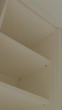 Modern iç tasarımın anahtar unsurları olarak boş gardırop rafları. Dikey çekim. Yavaş panoramik hareket.