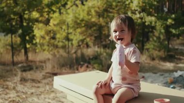 Neşeli bir çocuk mutlu bir şekilde açık hava ortamında oynuyor. Saf neşe, mutluluk ve mutluluk saçıyor.