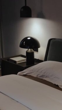  Dikey ekran: şık ışıklandırma ve minimalist zarafetle tamamlanmış zarif dekorlar sergileyen sakin ve modern bir yatak odası. 4k