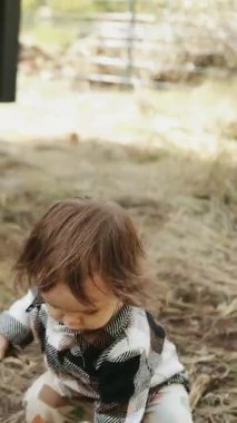 Dikey video. Neşeli bir çocuk dışarıda oynuyor, tasasız ruhlarını ve meraklarını kucaklıyor. 4k