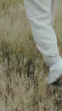  Dikey ekran: Neşeli bir insan yemyeşil çimenlerde dolaşır, sükuneti somutlaştırır ve doğayla derin bir bağ kurar