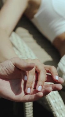 Birbirine dolanmış iki eli tasvir eden hassas bir an, insanlar arasında derin bir bağı ve sevgiyi simgeliyor.