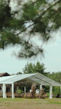 Neşeli Kutlama Düğününüz için Doğa Çevrelerinde Yuvalanmış Zarif Açık Hava Etkinlikleri Pavyonu. Dikey video. 4k