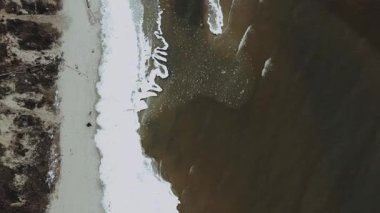 Güzel bir kumsal gösteriminin çarpıcı bir görüntüsü. Eşsiz kum yazma tasarımlarıyla birlikte dalgalar çarpıyor.