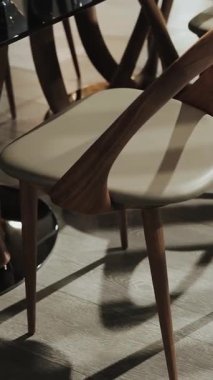 Modern sandalyelerin eşsiz bir şekilde tasarlanıp gölgeli oyunlar sergilediği zarif bir yemek seti. Dikey çekim. 