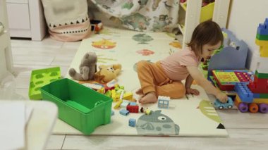 Oyuncu bir çocuk kapalı bir ortamda çeşitli oyuncaklardan hoşlanır, yaratıcılığı ve öğrenmeyi teşvik eder..