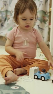 Bebek renkli oyuncakları keşfediyor, odasında mutlu bir şekilde oynuyor, merak dolu neşeli bir yer..