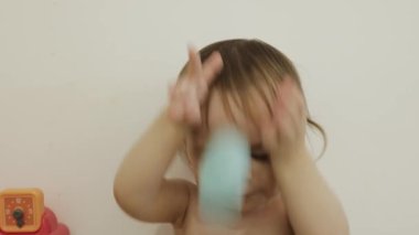 Neşeli bir çocuk renkli bardaklarla oynar, yaratıcılığını harikalarla dolu canlı bir ortamda gösterir. 4k