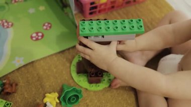 Genç bir çocuk, oyun sırasında yaratıcılığı ve eğlenceyi teşvik eden renkli yapı taşlarıyla hoş bir şekilde bağlantı kuruyor. 4k