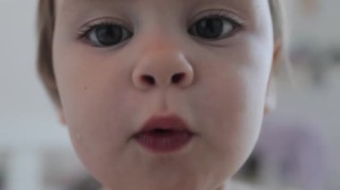 Sevinçle çevrelenmiş çeşitli neşeli ve komik ifadeler gösteren sevimli küçük bir çocuk.