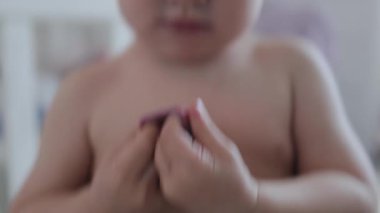 Neşeli bir çocuk renkli plasticinle oynar, gülümser ve kameraya bakar, yaratıcı yeteneklerini ve araştırma yeteneklerini gösterir. 4k