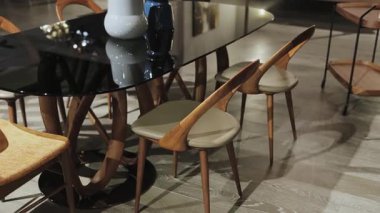 Bu şık yemek alanında, gösterişli cam bir masa ve ambiyansı arttıran modern ahşap sandalyeler var.