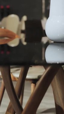 Modern tasarımın ahşap bacakları ve siyah cam yüzeyi olan bir karışımını sunan şık bir yemek masası..