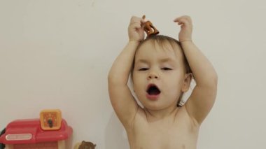 Neşeli bir çocuk neşeyle renkli bir oyuncak tutar, mutluluk dolu keyifli bir atmosfer yaratır.