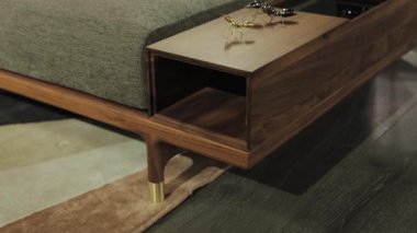 Pratik işlevsel depolama alanı ile tamamlanmış modern bir tasarımı barındıran ahşap bir yatak çerçevesinin yakın çekimi. 4k