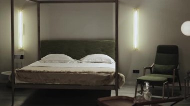 Zarif bir şekilde tasarlanmış bir yatak odası güzel bir tepe örtüsü, sofistike bir ışıklandırma ve minimalist bir tasarım içeriyor.