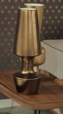 Oturma odası dekoru eşsiz bir pirinç lamba ve ahşap bir komodinin üzerinde vazo, şık bir iç mekan.
