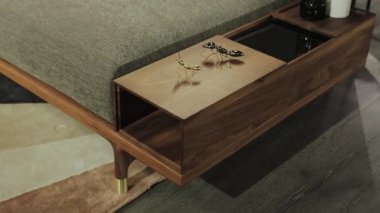 Şık ve şık dekorasyon ürünlerinin yanında eşsiz depolama seçenekleri sunan zarif bir ceviz sehpası.