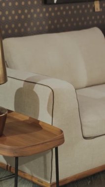 Yakın çekim görüntüsü. Modern Oturma Odası 'nda bir yan masa eşliğinde şık bir kanepe. Dikey video. 4k