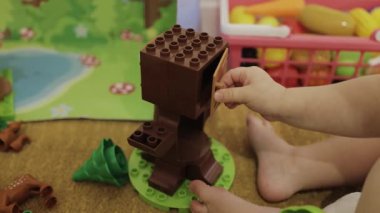 Genç bir çocuk renkli oyuncak blokları kullanarak yaratıcı bir aktiviteye girişir. Elleri yakın çekim. 4k