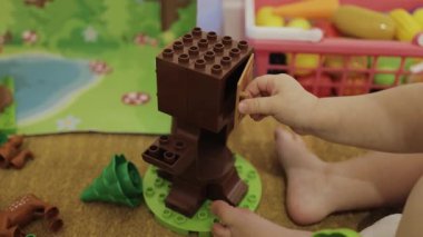 Genç bir çocuk renkli oyuncak blokları kullanarak yaratıcı bir aktiviteye girişir. Elleri yakın çekim. 4k