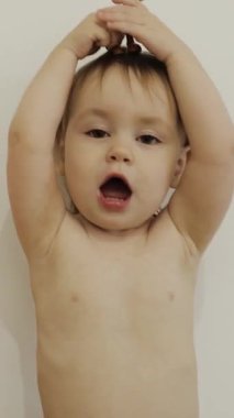 Neşeli çocuk odasında renkli oyuncak bir hayvanla oynuyor, neşe ve yaratıcılık saçıyor. Bezli çocuk. Dikey video 4k