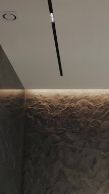 Modern bir iç mekanda duvardaki siyah mermer dokusu. Lüks, modern bir apartmanın içinde. Doğal taş granit. Dikey çekim. 
