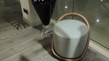 Kumaş bir sandalye ve dekoratif bir vazo iç mekanın lüksüne vurgu yapıyor. Lüks, modern bir apartmanın içinde. Minimalist oturma odası. Yüksek kalite 4k görüntü