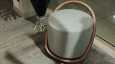 Yumuşak kumaş koltuklu ve ahşap çerçeveli modern bir tabure. İç kısımda sandalye var. Kimse vurulmayacak. Yüksek kalite 4k görüntü