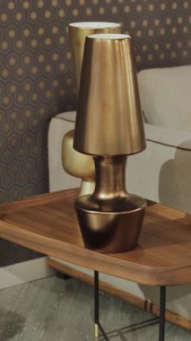 Lambalar yatağın yanındaki ahşap masada duruyor. Şık bir lambası ve rahat bir kanepesi olan zarif ve güzel bir oturma odası. Dikey çekim. - Evet. Yüksek kalite 4k görüntü