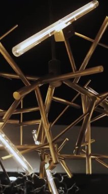 Siyah arkaplandaki metalik altın avizeye yakın plan herhangi bir iç tasarım için eşsiz tasarım elementleri. Dikey çekim. Yüksek kalite 4k görüntü