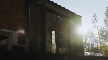 Altın güneş ışığı yemyeşil yemyeşil bir kulübe üzerine çöker, huzur ve rahatlamaya davetiye çıkarır. Siyah metalin üzerindeki mercekler küçük bir evde alev alır. Yüksek kalite 4k görüntü