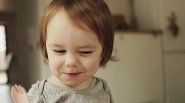 Neşeli bir çocuk neşeli bir ifadeyle yemeğin tadını çıkarıyor, keyifli yemek anlarını yakalıyor. Yüksek kalite 4k görüntü